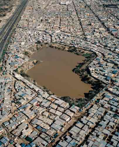 « Township de Dunoon, Le Cap, Afrique du Sud, 2018. » Un étang d’eau insalubre est niché au coeur de cette zone pauvre, qui compte près de 12 000 foyers.