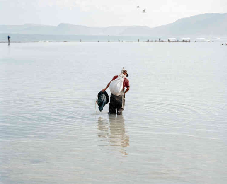 « Andrew, chasseur de vers au pavillon Strandfontein. Le Cap, Afrique du Sud, 2018. » Un homme cherche des vers dans le bassin de marée peu profond du pavillon Strandfontein pour les vendre ensuite aux pêcheurs locaux.