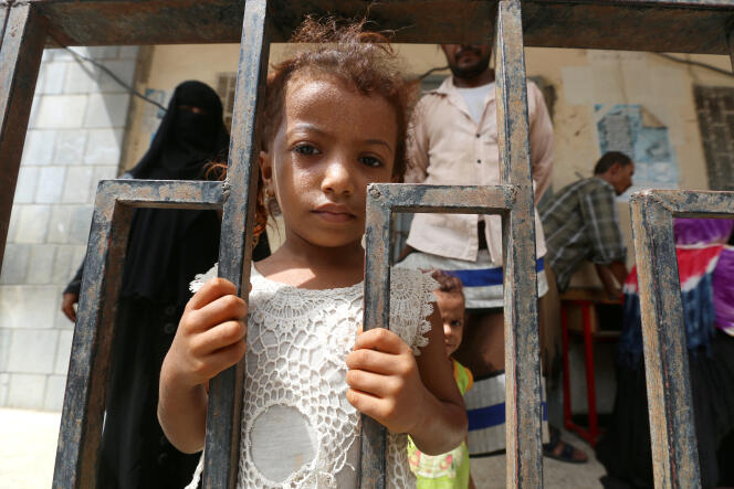Une petite fille devant la grille d’une école où elle s’est réfugiée avec sa famille après avoir été évacuée d’un village voisin, près de Hodeïda, au Yémen, en juin.