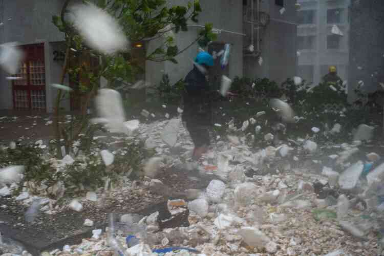 Un photojournaliste parmi les débris plastiques soufflés par la tempête à Hongkong, le 16 septembre. Les autorités chinoises ont indiqué avoir évacué plus de 3 millions de personnes dans le sud du pays.