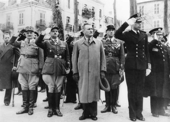 Joseph Darnand, secrétaire général au maintien de l'ordre, et le sous-préfet de Vichy, pendant la minute de silence lors de la prise d'armes au monument aux morts à Vichy, vers 1940.