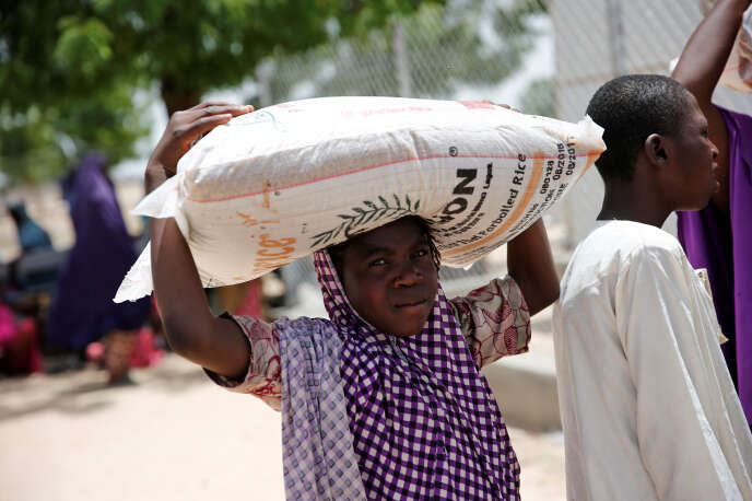 Une femme porte un sac de riz distribué par une ONG dans le camp de réfugiés de Maiduguri, dans le nord-est du Nigéria, en juin 2017.