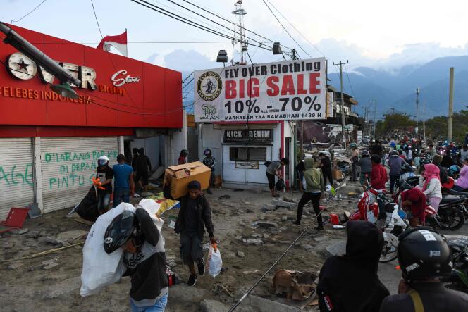 Des survivants du séisme et du tsunami se servent dans les stocks d’un magasin de vêtements à Palu, en Indonésie, le 1er octobre.