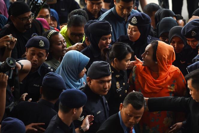 Rosmah Mansor (à droite, en tenue orange), lors de son arrivée à la cour de justice de Kuala Lumpur le 4 octobre.