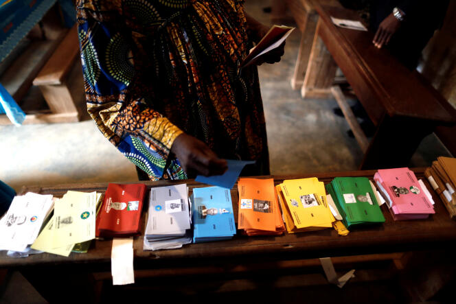 Une femme prend les bulletins de vote, dimanche 7 octobre, au Cameroun, qui doit élire son nouveau président de la République.