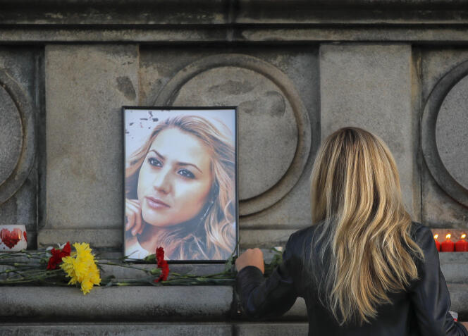 Une femme dépose une rose devant le portrait de la journaliste assassinée Viktoria Marina, devant le monument de la liberté, à Ruse, en Bulgarie le 8 octobre.