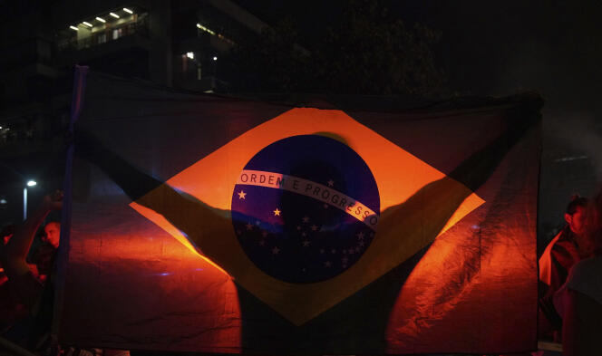 Un homme brandit un drapeau du Brésil à l’annonce du résultat du premier tour de l’élection présidentielle, donnant Jair Bolsonaro vainqueur, le 7 octobre à Rio de Janeiro.