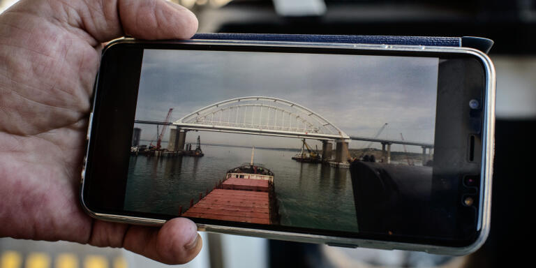 Le capitaine Igor Zavialiov du cargo Salvinia montre des photos du pont entre la russie et la crimée traversant la mer d'Azov. Marioupol. Ukraine.
