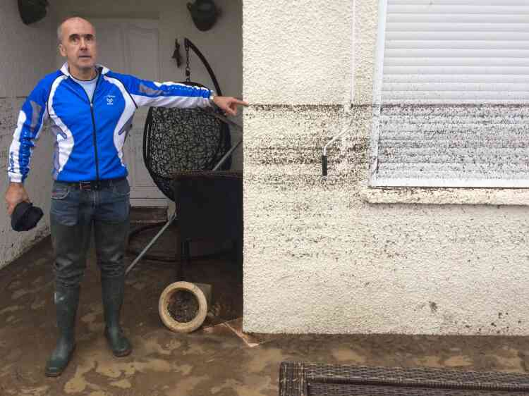 Un résident montre le niveau atteint par l’eau lors des inondations à Villegailhenc, près de Carcassonne, dans le sud de la France. Le niveau atteint lundi matin par la crue à Trèbes, dans la vallée de l’Aude, est sans précédent depuis 1891, c’est-à-dire « pas loin de sept mètres », a déclaré à l’AFP le service Vigicrues.