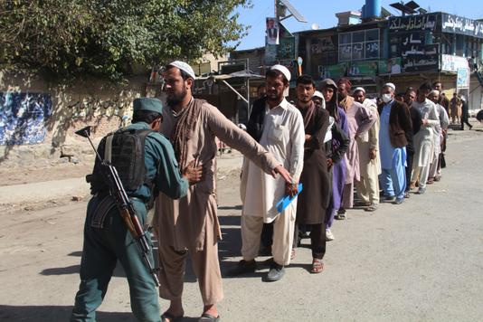 Un policier fouille les électeurs qui se présentent à un bureau de vote, dans la province afghane de Khost, le 20 octobre.