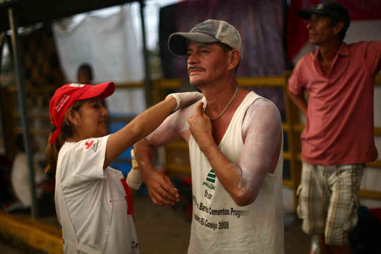 Sur le pont d’Hidalgo, entre le Guatemala et le Mexique, une membre de la Croix-Rouge aide un homme à se mettre de la crème solaire, le 21 octobre.