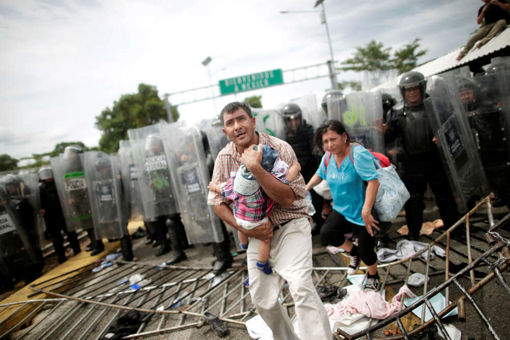 Un homme protÃ¨ge son enfant Ã  Hidalgo, une ville Ã  la frontiÃ¨re entre le Guatemala et le Mexique. Jeudi 18 octobre, les autoritÃ©s mexicaines Ã©taient parvenues Ã Â bloquer la caravane.
