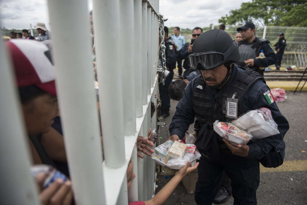 Un policier mexicain distribue des repas aux migrants sur le pont dâ€™Hidalgo le 20 octobre.Â Donald Trump a rappelÃ© par un tweet que les migrants qui voulaient entrer aux Etats-Unis devait dâ€™abord faire une demande dâ€™asile au Mexique (le 20 octobre).