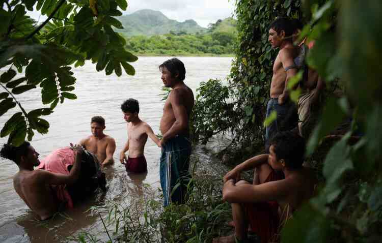 Des migrants honduriens se préparent à traverser la Goascorán, le 18 octobre, afin d’entrer illégalement au Salvador et de rejoindre la caravane de migrants qui se dirige vers les Etats-Unis.