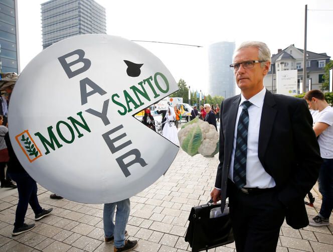 Un actionnaire de Bayer devant un manifestant contre la fusion entre Monsanto et Bayer, à Bonn (Allemagne), le 25 mai.
