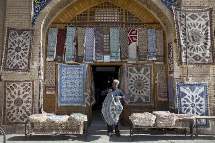 Un vendeur de tapis devant sa boutique à Ispahan .