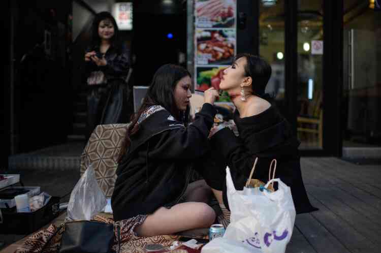 Séance de maquillage dans une rue du quartier populaire de la vie nocturne d’Itaewon à Séoul le 27 octobre.