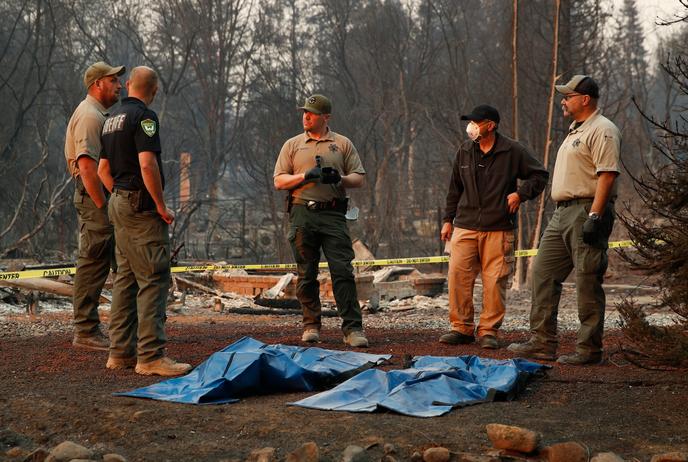 Des responsables locaux devant les corps de victimes de l’incendie « Camp Fire », à Paradise, le 11 novembre.