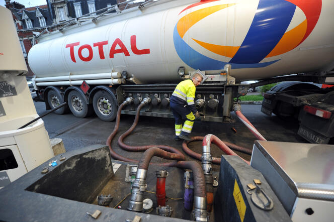 Un employé de Total approvisionne en carburant une station-service à partir d'un réservoir, en février 2011, à Lille.