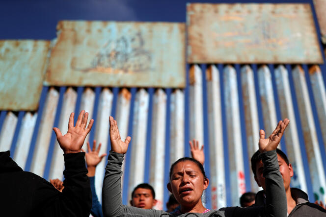 Après avoir parcouru près de  4 300 km, des migrants de la « caravane » en prière devant la frontière avec les Etats-Unis, à  Tijuana (Mexique), le 15 novembre.