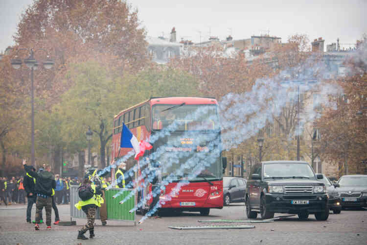 La police procède à des tirs de grenades lacrymogènes sur les Champs-Elysées à Paris.