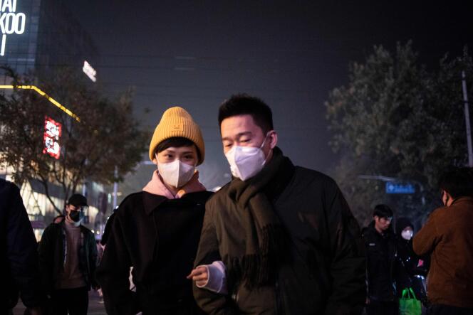 Un couple se protège contre la pollution de l’air à Pékin, fin novembre.