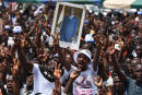 Supporters of the opposition coalition Together for Democracy and Sovereignty (EDS), a coalition that gathers civil society groups as well as the Ivorian People's Party, the party of former president Laurent Gbagbo, hold up a poster of Gbagbo during a rally on July 28, 2018 in Yopougon a working class district of Abidjan. (Photo by Sia KAMBOU / AFP)