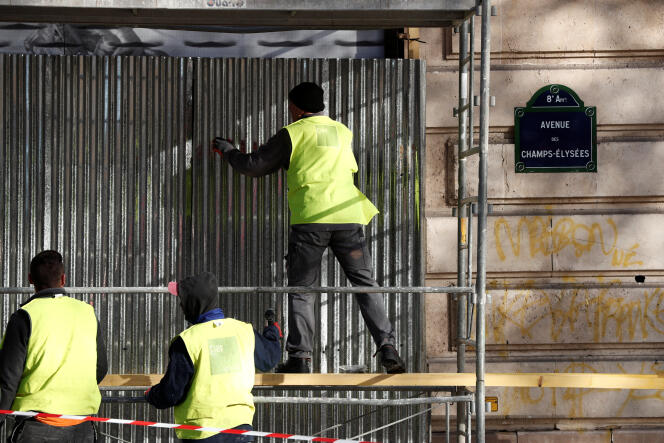 Des vitrines sont protégées à la veille du rassemblement des « gilets jaunes », sur les Champs-Elysées, le 30 novembre.