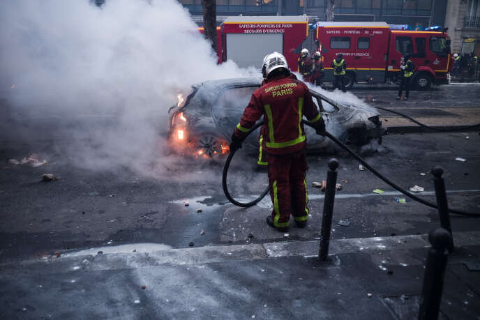 Manifestation des « gilets jaunes » autour de la place de l’Etoile. La brigade de sapeurs-pompiers de Paris intervient pour éteindre des voitures en feu, avenue Kléber.