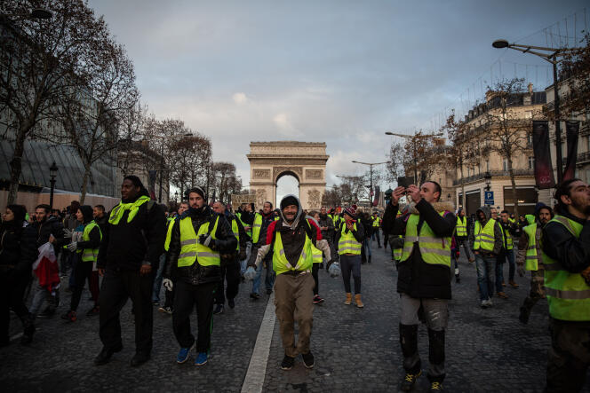 Les gilets jaunes descendent les Champs-Elysées en début de manifestation.