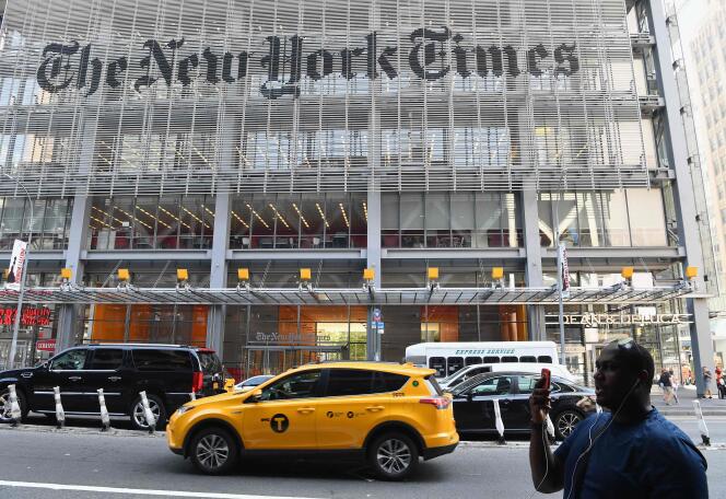 Un passant consulte son téléphone portable devant le « New York Times », à New York, le 6 septembre 2018.