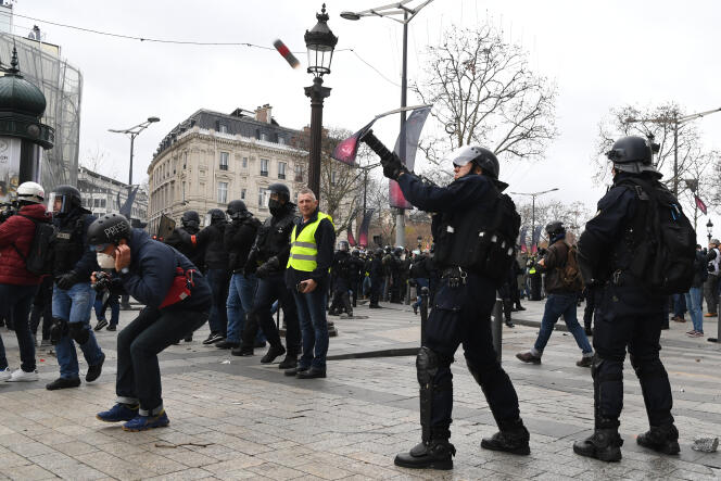 Tir de gaz lacrymogène par un policier près d’un journaliste sur les Champs-Elysées, à Paris, le 8 décembre 2018, lors d’une manifestation des « gilets jaunes ».