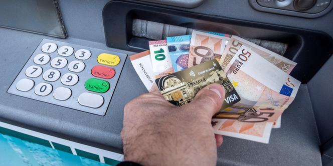 Retrait d’argent à un distributeur automatique de billets, à Lille, le 4 janvier 2017.