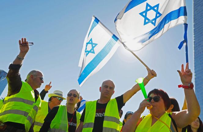Des « gilets jaunes » israéliens brandissent leur drapeau national lors d’une manifestation contre la hausse du coût de la vie, le 14 décembre 2018.