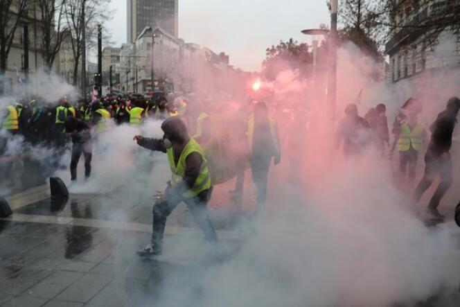 Des manifestants courent au milieu des gaz lacrymogènes, cours des Cinquante-Otages, à Nantes, le 15 décembre.
