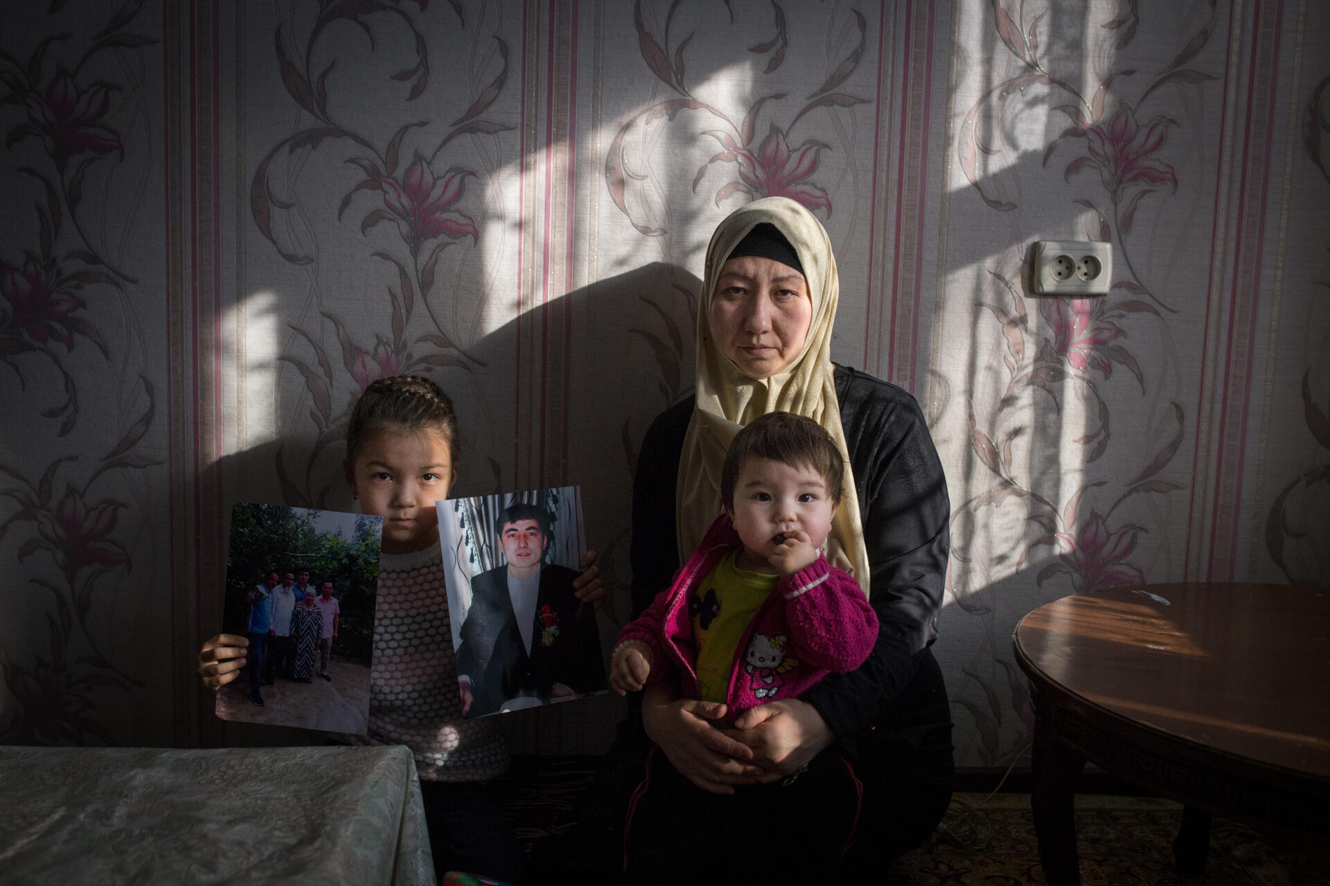 Guzel Basitova, 34 ans, et ses enfants. Mounissa, à gauche, tient le portait de son père, détenu en Chine depuis un an. A Almaty, au Kazakhstan, en décembre 2018.