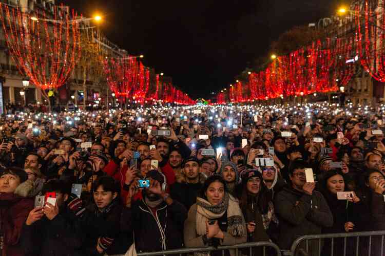 La foule, 250 000 personnes selon la préfecture de police, attend minuit sur les Champs-Elysées.
