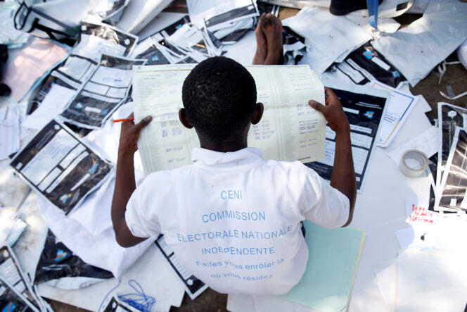 Un membre de la Commission électorale nationale indépendante examine un bulletin de vote dans un centre de Kinshasa le 1er janvier.
