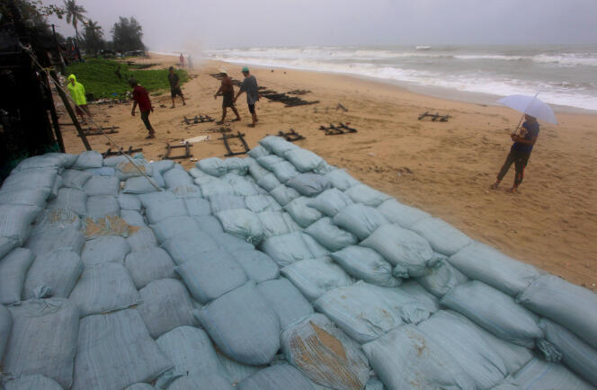 Des Thaïlandais placent des sacs de sable afin de protéger les propriétés en bord de mer à Songkhla, à l’approche de la tempête Pabuk, jeudi 3 janvier.