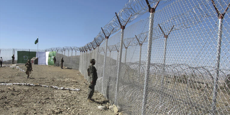 Pakistani soldiers stand guard at newly erected fence between Pakistan and Afghanistan at Angore Adda, Pakistan, Wednesday, Oct. 18, 2017. Pakistan's military says new fencing and guard posts along the border with Afghanistan will help prevent militant attacks, but the stepped-up fortifications have angered Kabul, which does not recognize the frontier as an international border. (AP Photo/Mohammad Yousaf)
