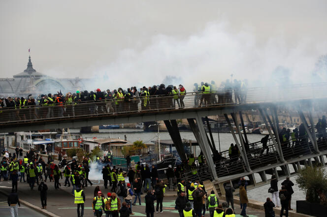 Des « gilets jaunes » sont repoussés par des gaz lacrymogènes lancés par les forces de l’ordre, samedi 5 janvier à Paris.