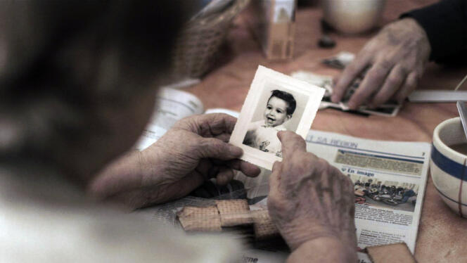 Capture d’écran du film projeté pendant le spectacle « Retour à Reims » où la mère de Didier Eribon montre une photo de lui enfant.