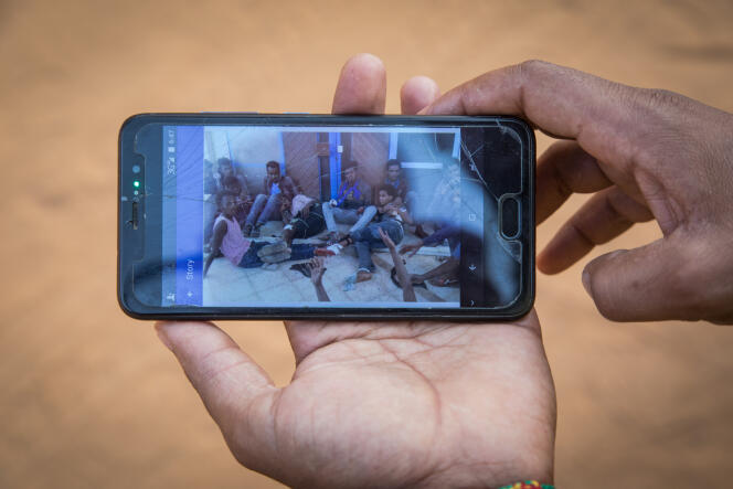 Sur son téléphone, Abraham fait défiler des photos prises en Libye lorsqu’il était détenu dans des hangars par des passeurs.