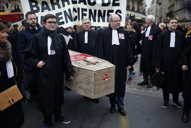Des avocats tiennent un cercueil alors qu’ils manifestent contre un projet de loi du gouvernement sur la justice, à Paris, le mardi 15 janvier 2019.