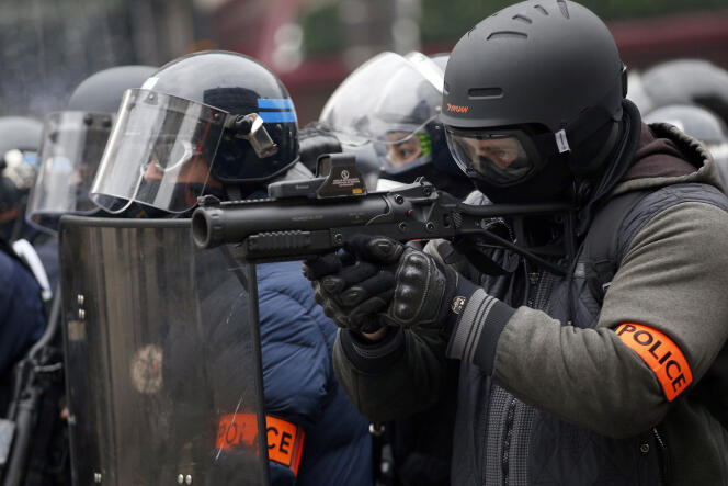 Un policier armé d’un lanceur de balle de défense, lors d’une manifestation des « gilets jaunes », sur les Champs-Elysées, le 15 janvier.