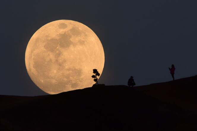 (FILES) In this file photo taken on January 30, 2018, a person poses for a photo as the moon rises over Griffith Park in Los Angeles, California. The space agencies of the United States and China are in touch and coordinating efforts on Moon exploration, NASA said on January 18, 2019, as it navigates a strict legal framework aimed at preventing technology transfer to China. / AFP / Robyn Beck
