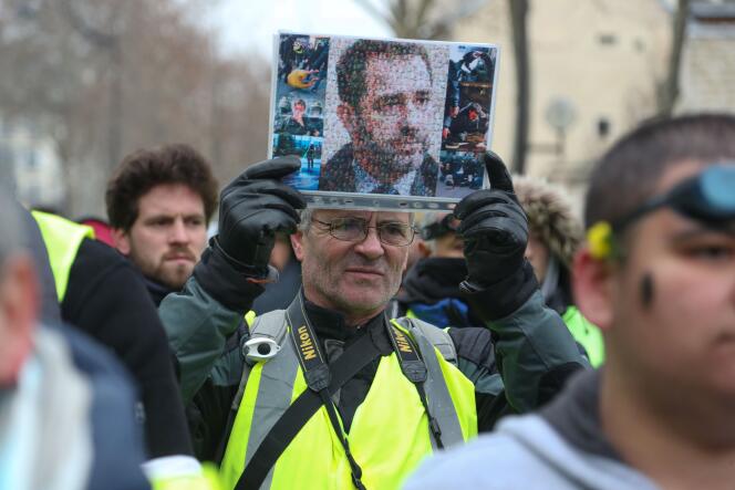 Un « gilet jaune » brandit une mosaïque faite d’image de manifestant blessés depuis le début du mouvement et représentant le ministre de l’intérieur Christophe Castaner, à Paris, le 19 janvier.