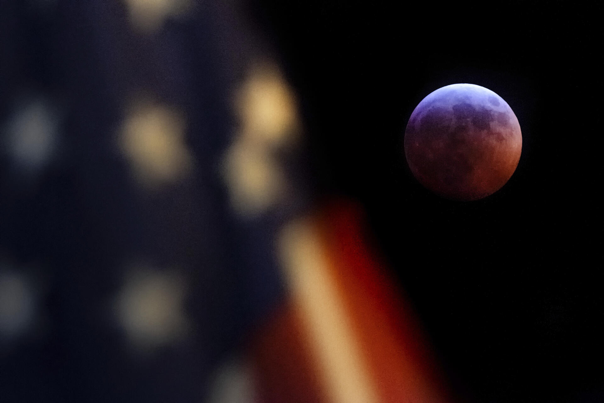 La Lune, en éclipse, côtoie le drapeau américain sur cette photographie prise à Washington.
