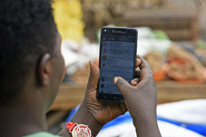 Une jeune Ougandaise naviguant sur l’application de messagerie instantanée WhatsApp, à Kampala, en juillet 2018.