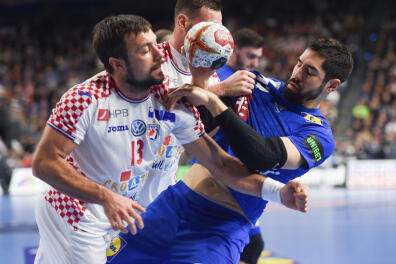 Croatia's Zlatko Horvat and France's Nikola Karabatic vie for the ball during the IHF Men's World Championship 2019 Group I handball match between France and Croatia at the Lanxess arena in Cologne, on January 23, 2019. / AFP / Patrik STOLLARZ
